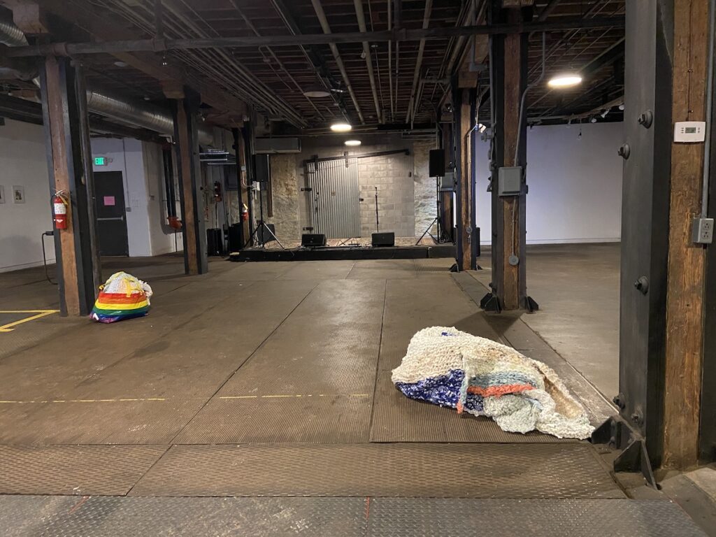 Two piles of fabric in large industrial room.