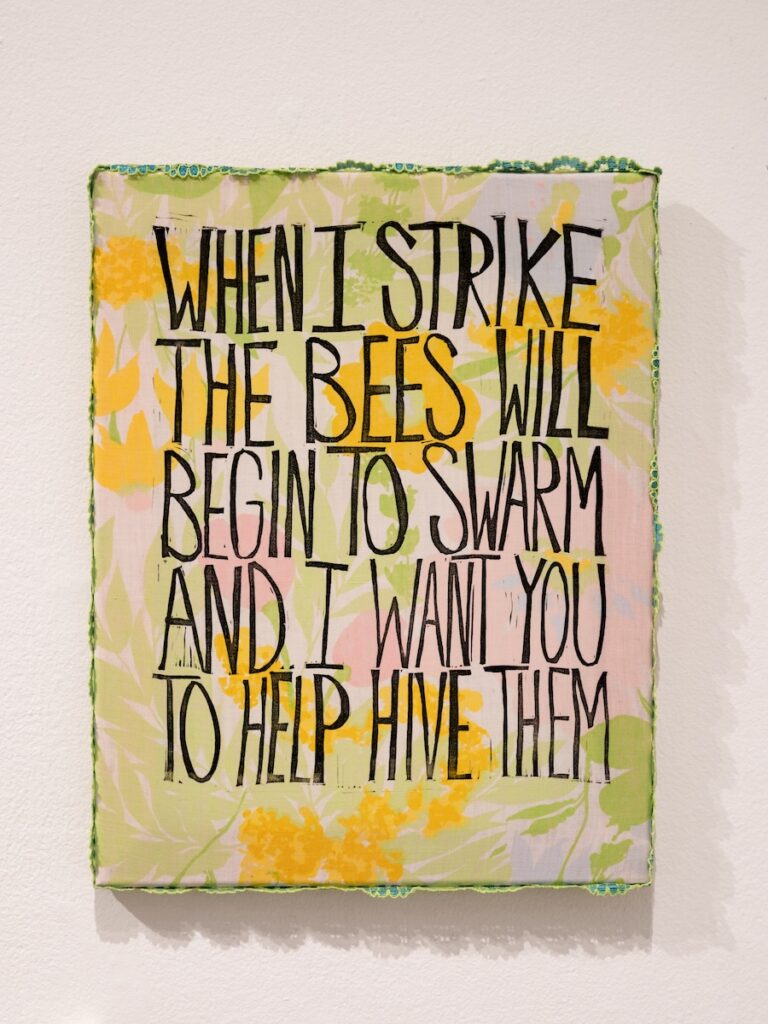 Text printed on a canvas hung on a wall.