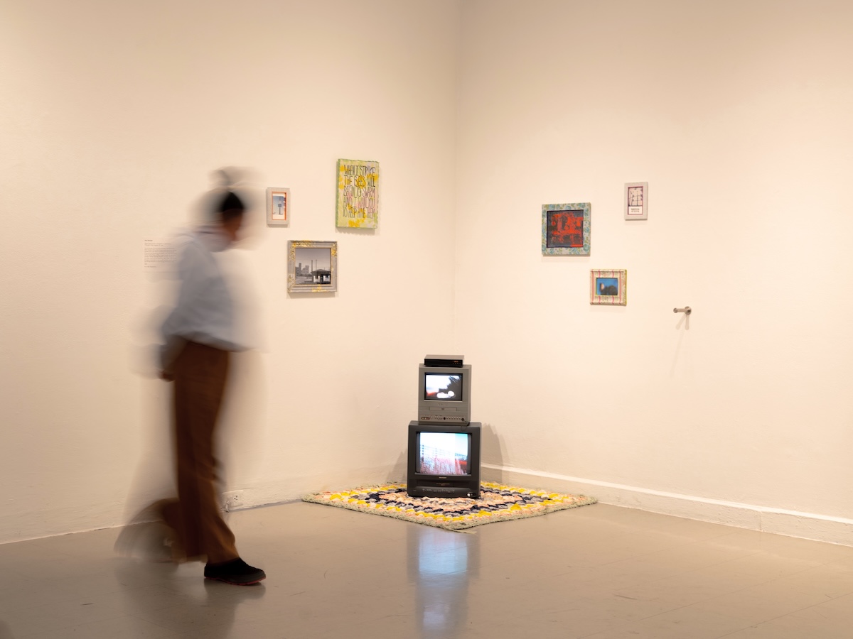 A person walks in front of an art installation. They are blurry.